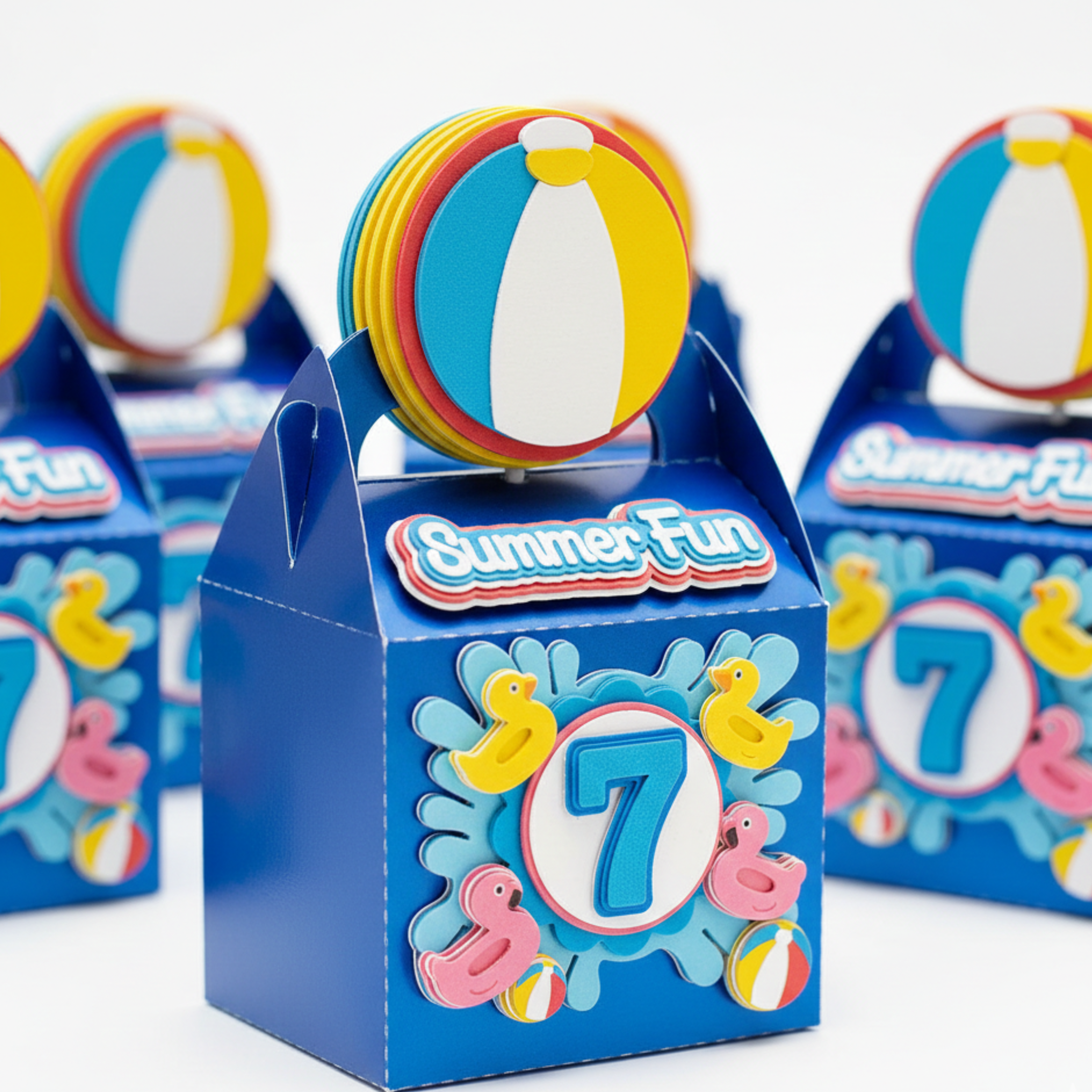 Blue party favor box with 'Summer Fun' and number '7' design, surrounded by beach ball decorations.