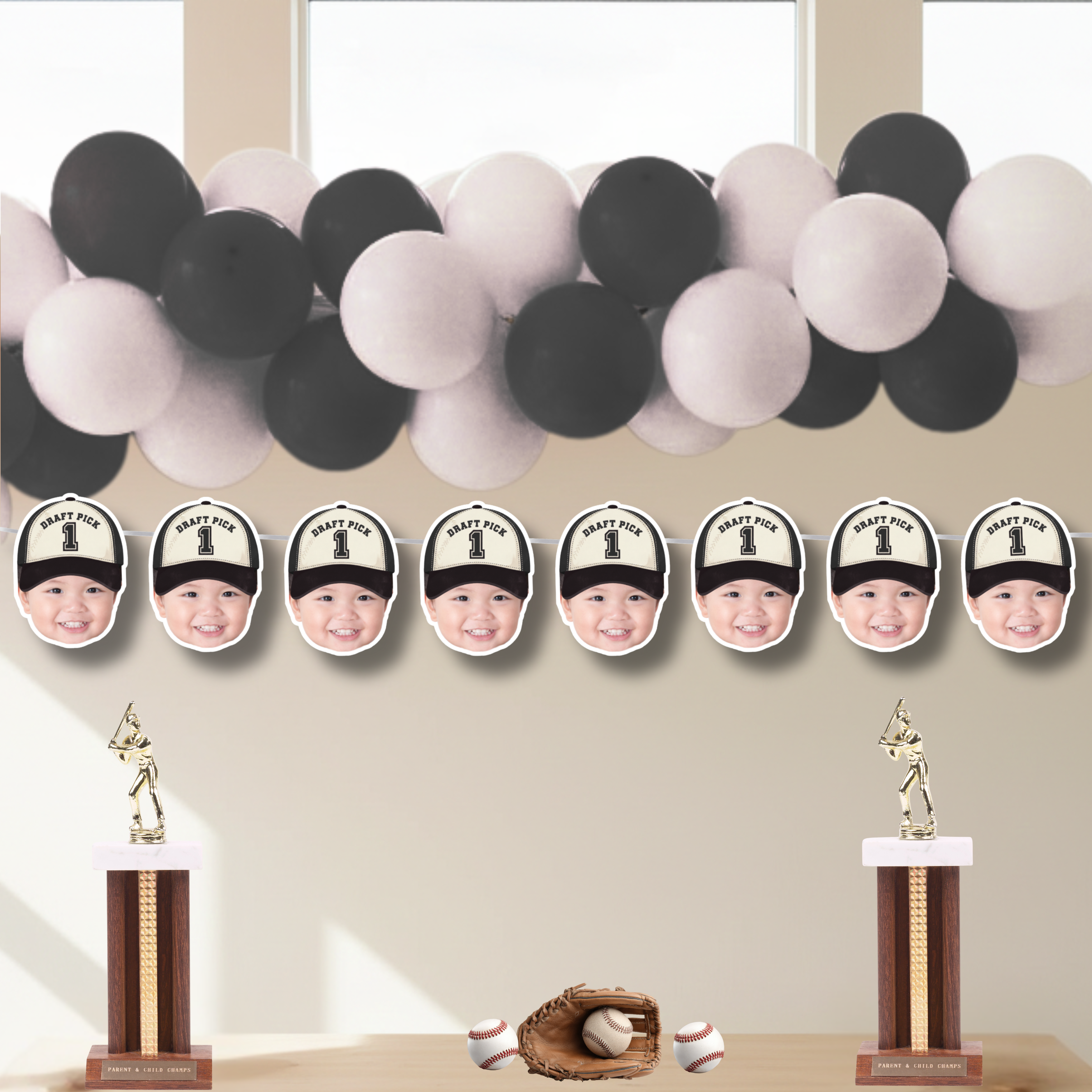 Rookie of the Year photo baseball banner with personalized Draft Pick 1 baby faces displayed under black and white balloon garland, styled as a modern sports birthday backdrop for baseball cake smash and little slugger celebration.