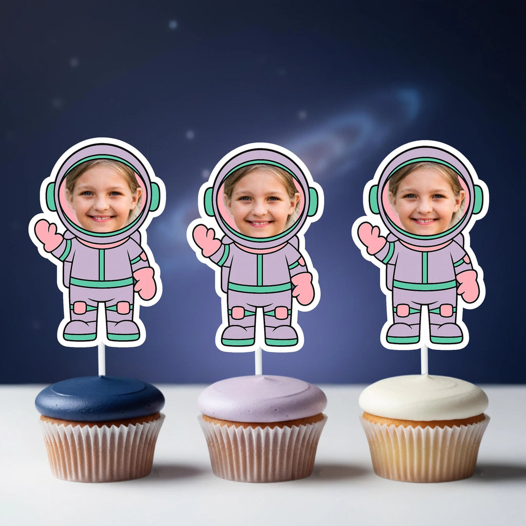 Three cupcakes with astronaut-themed toppers against a dark blue space-themed background