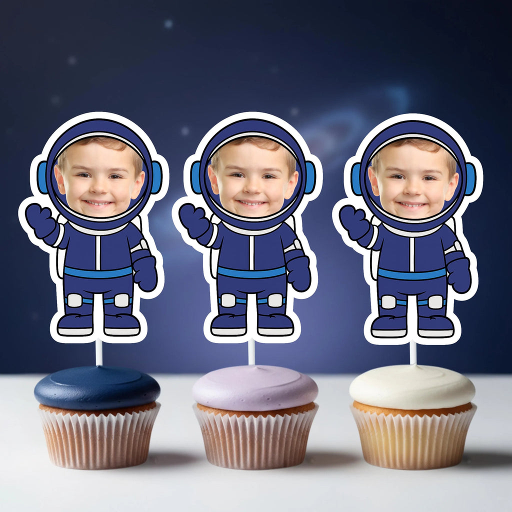 Three cupcakes with astronaut-themed toppers against a dark blue background