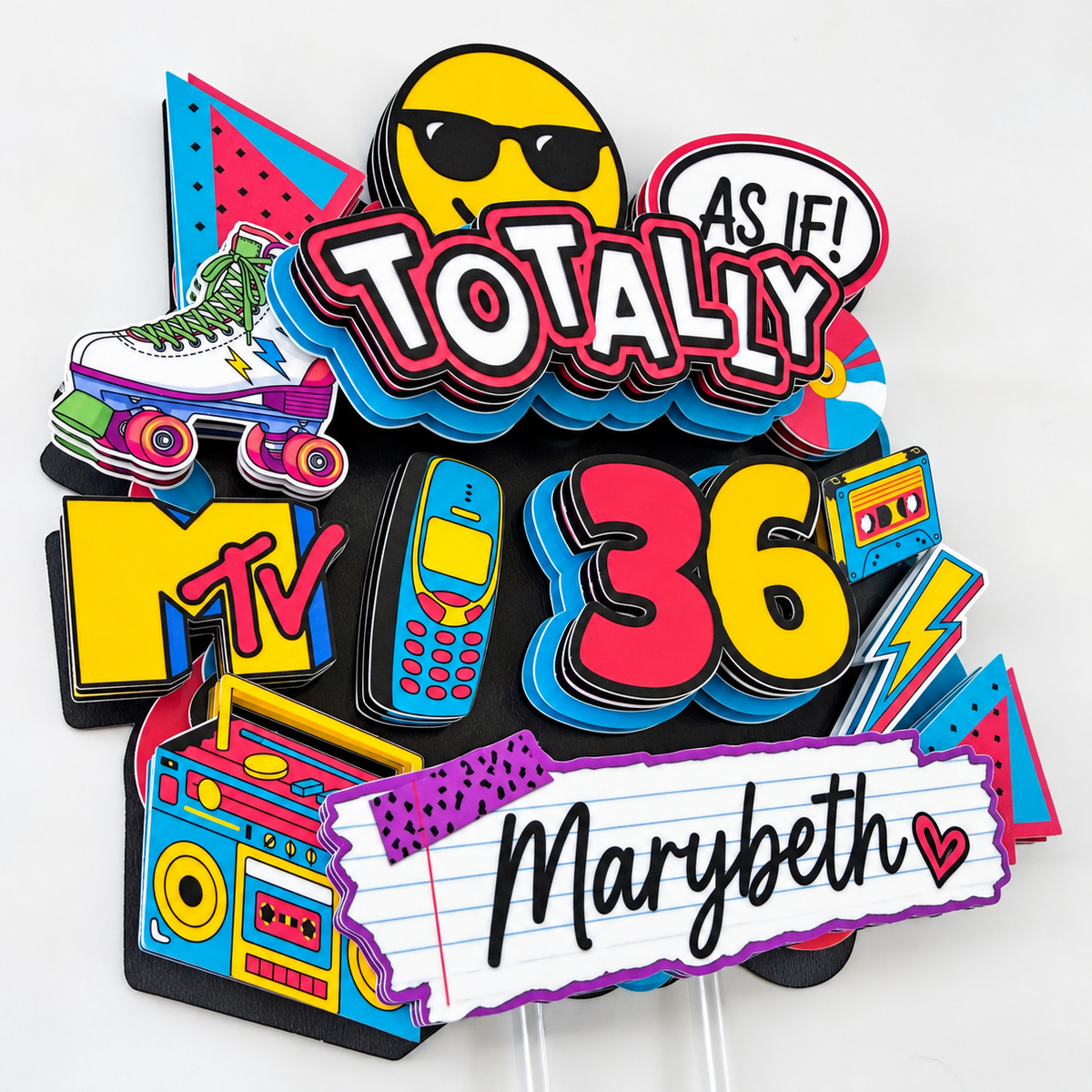 Closeup of a personalized Totally 90s retro cake topper with dimensional layered cardstock, custom age 36, Marybeth name and nostalgic 1990s graphics.
