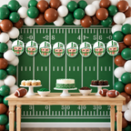 Personalized First Year Down football photo banner featuring eight child face panels in white and green football helmets displayed above a green football birthday dessert table