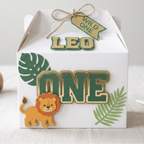Custom Wild One safari birthday party favor box featuring layered cardstock lion design, jungle leaf embellishments, raised number one centerpiece, and handmade safari themed first birthday packaging.