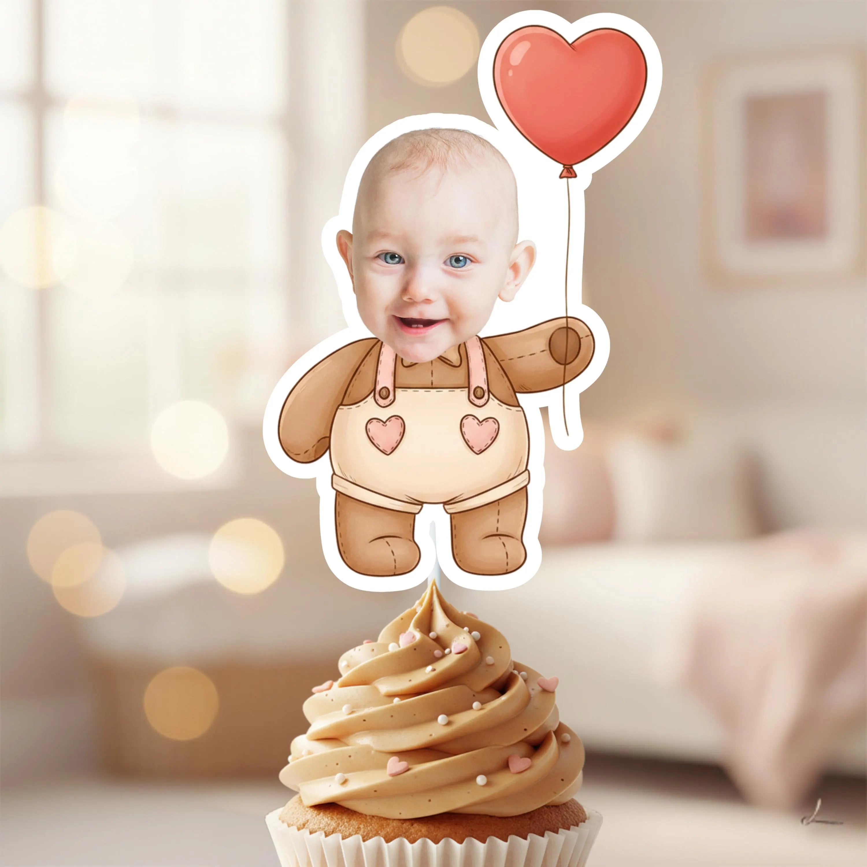Cupcake with a baby-themed topper featuring a heart balloon and a baby in a onesie.