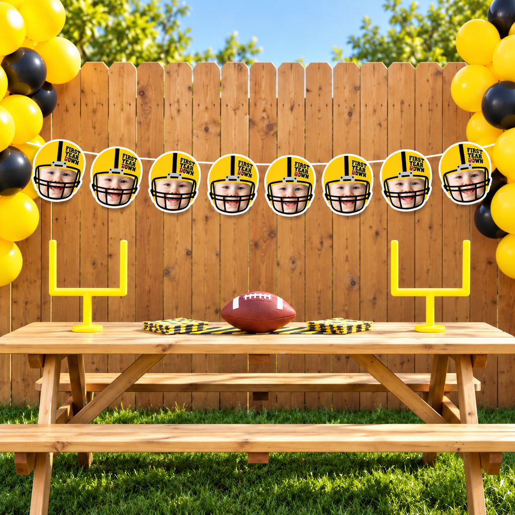 Personalized First Year Down football photo banner featuring eight child face panels in yellow football helmets displayed outdoors with yellow and black balloons for a football birthday party
