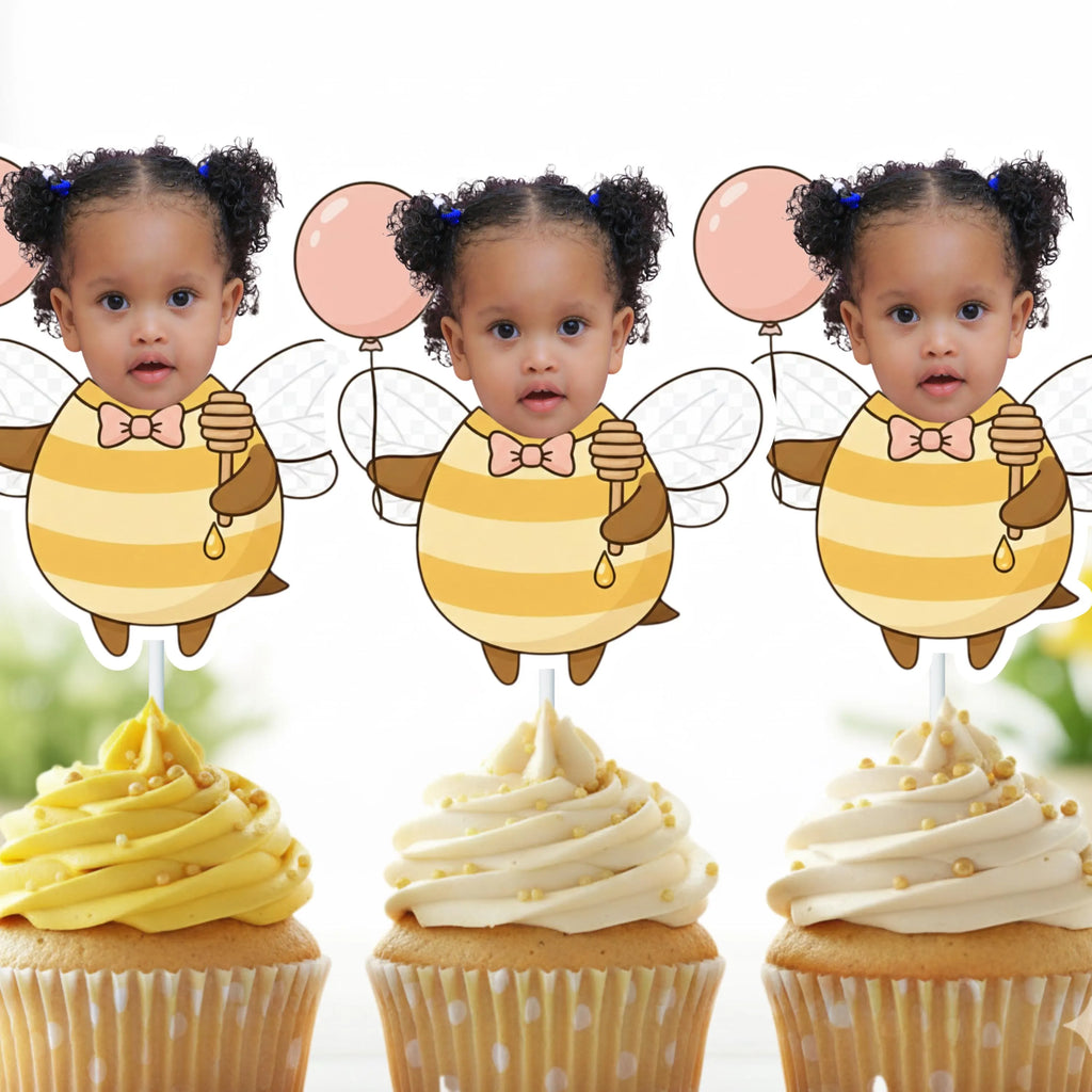Three identical cupcake toppers with a child's face and bee design on top of cupcakes.
