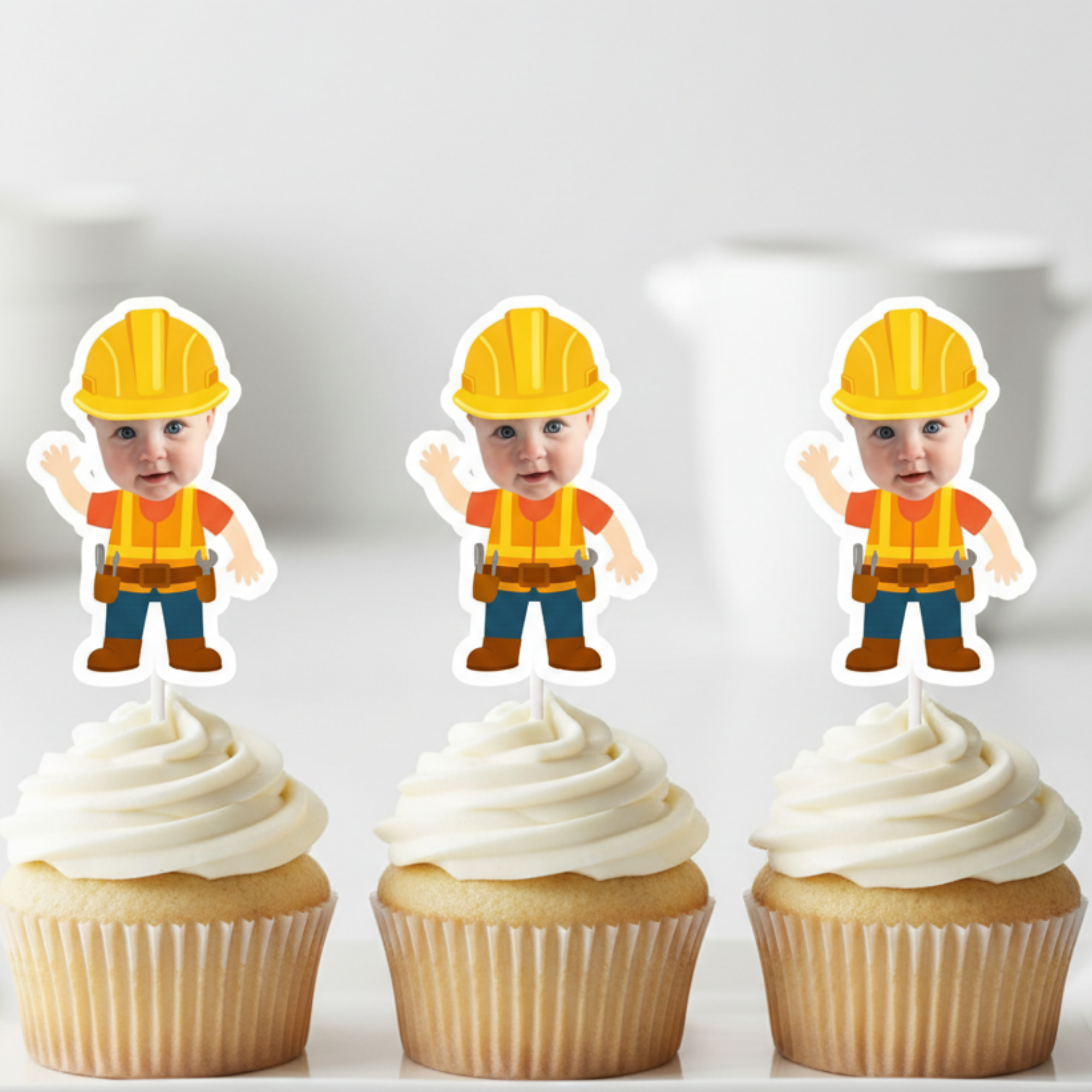 Three cupcakes with white frosting and construction-themed toppers on a light background