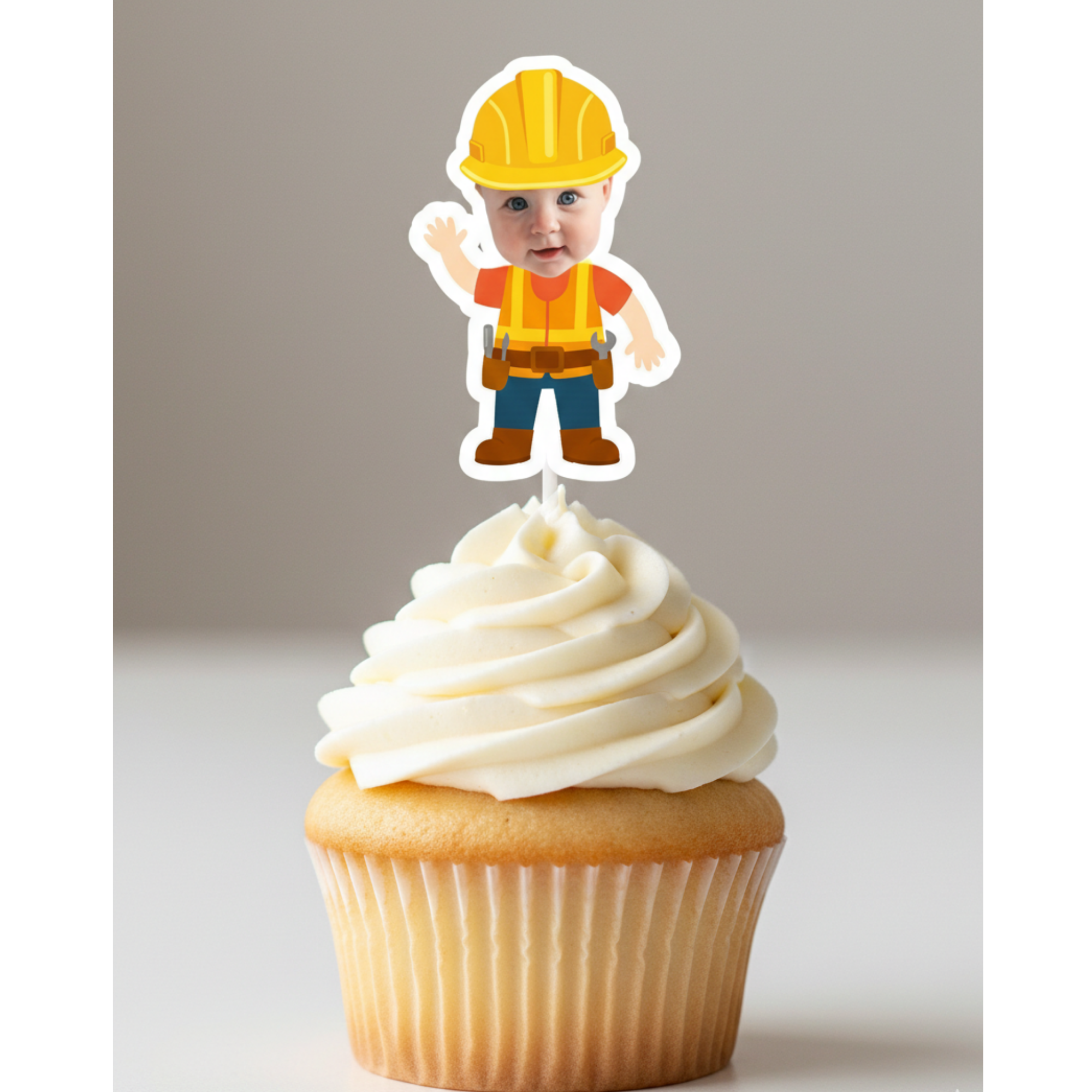 Cupcake with a construction worker topper on a plain background