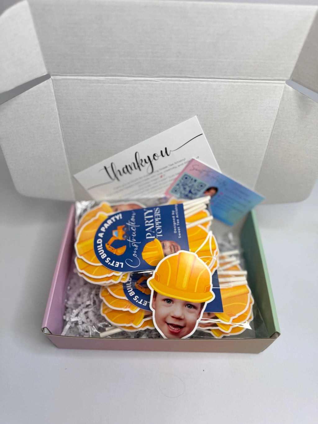 Box with construction-themed stickers featuring a child wearing a hard hat and a 'Thank you' card.