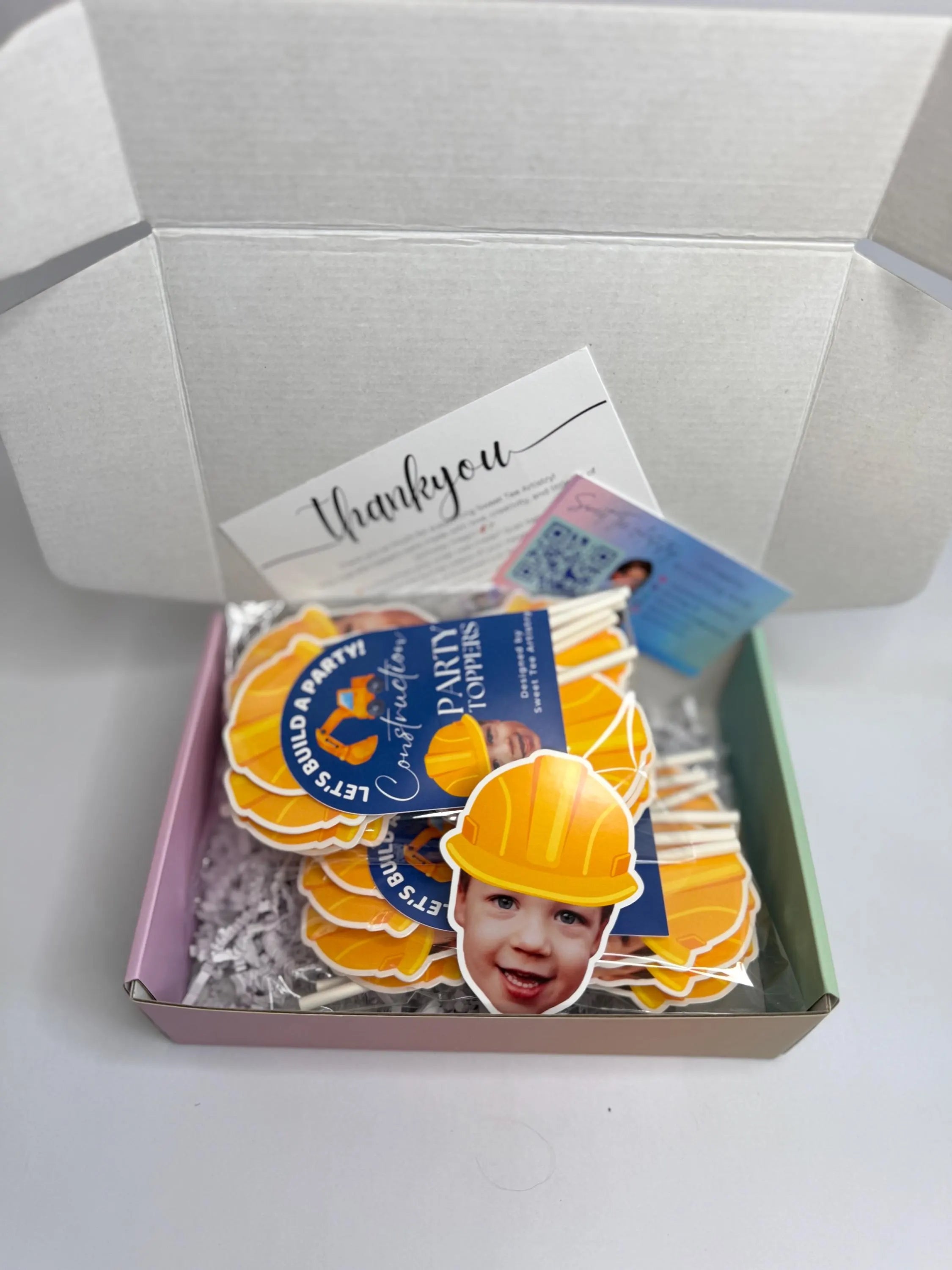 Box with construction-themed stickers featuring a child wearing a hard hat and a 'Thank you' card.