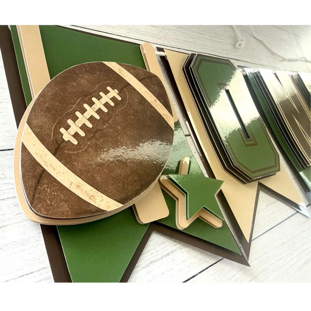 Detailed view of layered laminated cardstock construction on the First Year Down football highchair banner