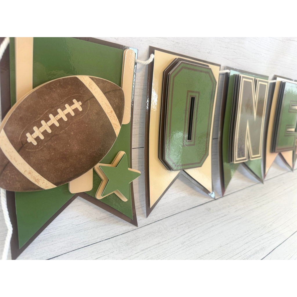 Closeup of layered football and star detail on the First Year Down football highchair banner