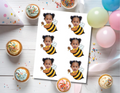 Printable sheet of six personalized honey bee photo cupcake toppers featuring a child’s face on a black-and-yellow flying bee with white wings and a honey dipper