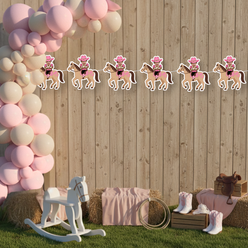 Personalized My First Rodeo cowgirl photo banner displayed on a rustic wood backdrop with pink balloon arch, perfect for a pink western first birthday party. This styled mockup shows the cowgirl photo banner hanging against a barn wood wall with blush balloons, hay bales, and western decor, ideal for cowgirl smash cake and rodeo birthday backdrops.