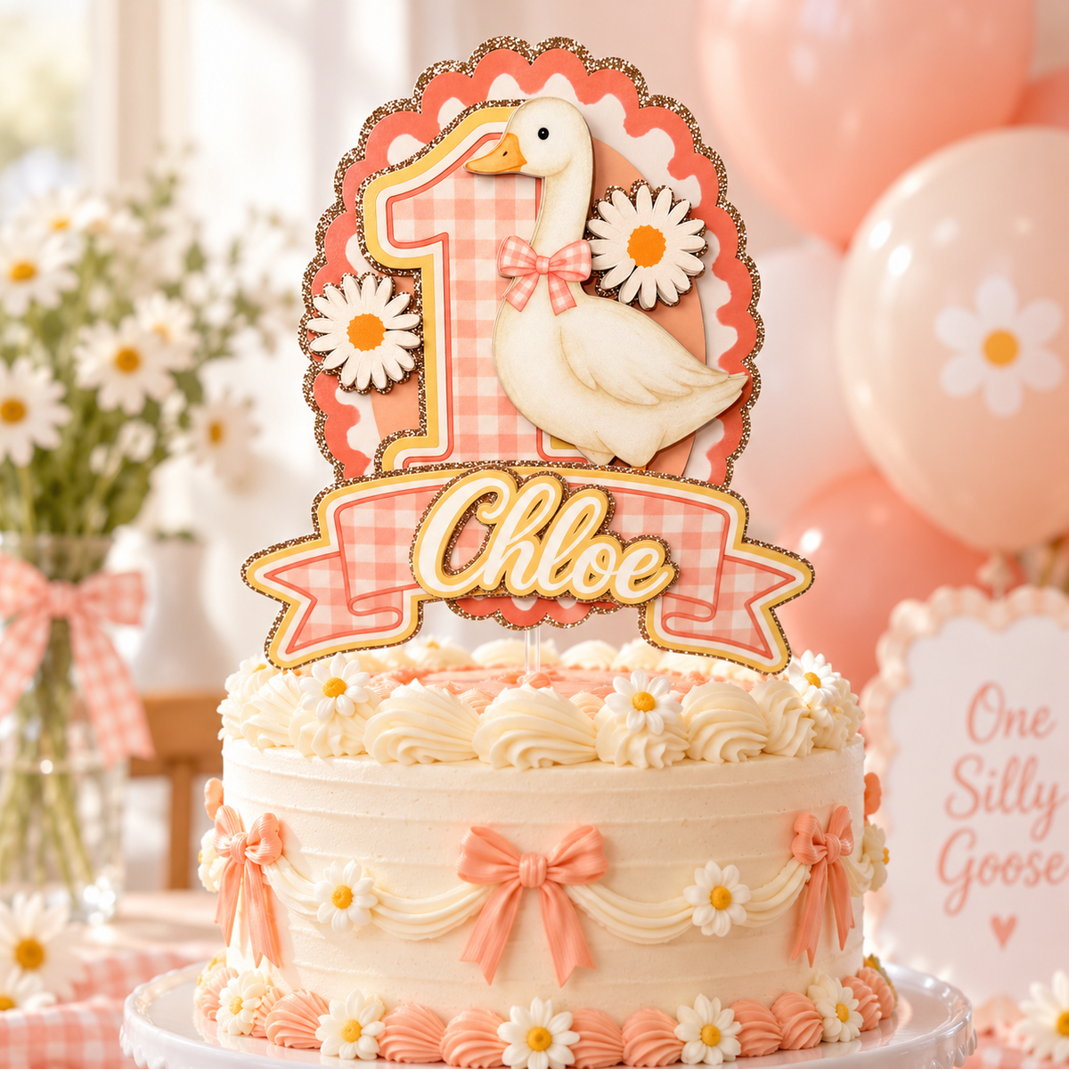 One Silly Goose first birthday cake topper displayed on a white cake with pink bows, daisies and soft pink party decorations