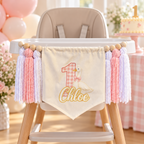Pink One Silly Goose personalized first birthday high chair banner displayed on a white high chair with soft pink balloons, gingham decor, and birthday cake.