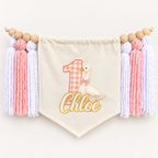 Pink One Silly Goose personalized first birthday high chair banner with custom name and age, cream canvas pennant, natural wooden beads, and pink and white yarn tassels.