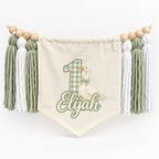 Sage green One Silly Goose personalized first birthday high chair banner with custom name and age, cream canvas pennant, natural wooden beads, and sage and white yarn tassels.