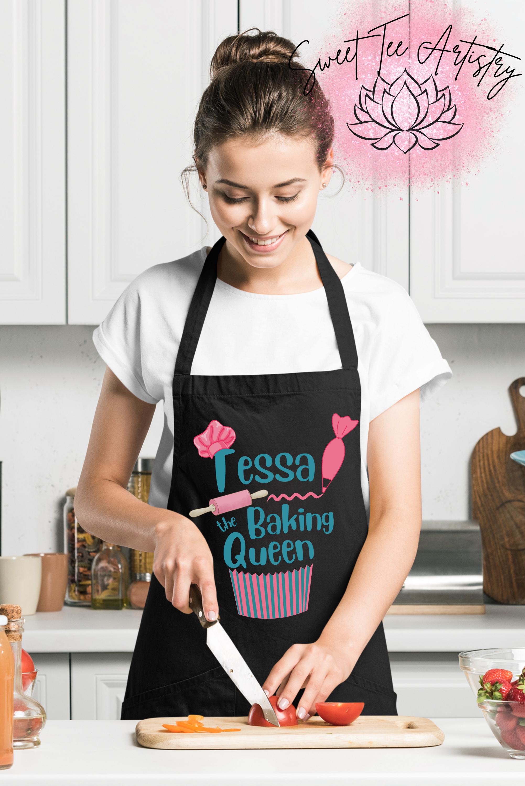Woman in a kitchen wearing a black apron with 'Tessa the Baking Queen' design, cutting vegetables.