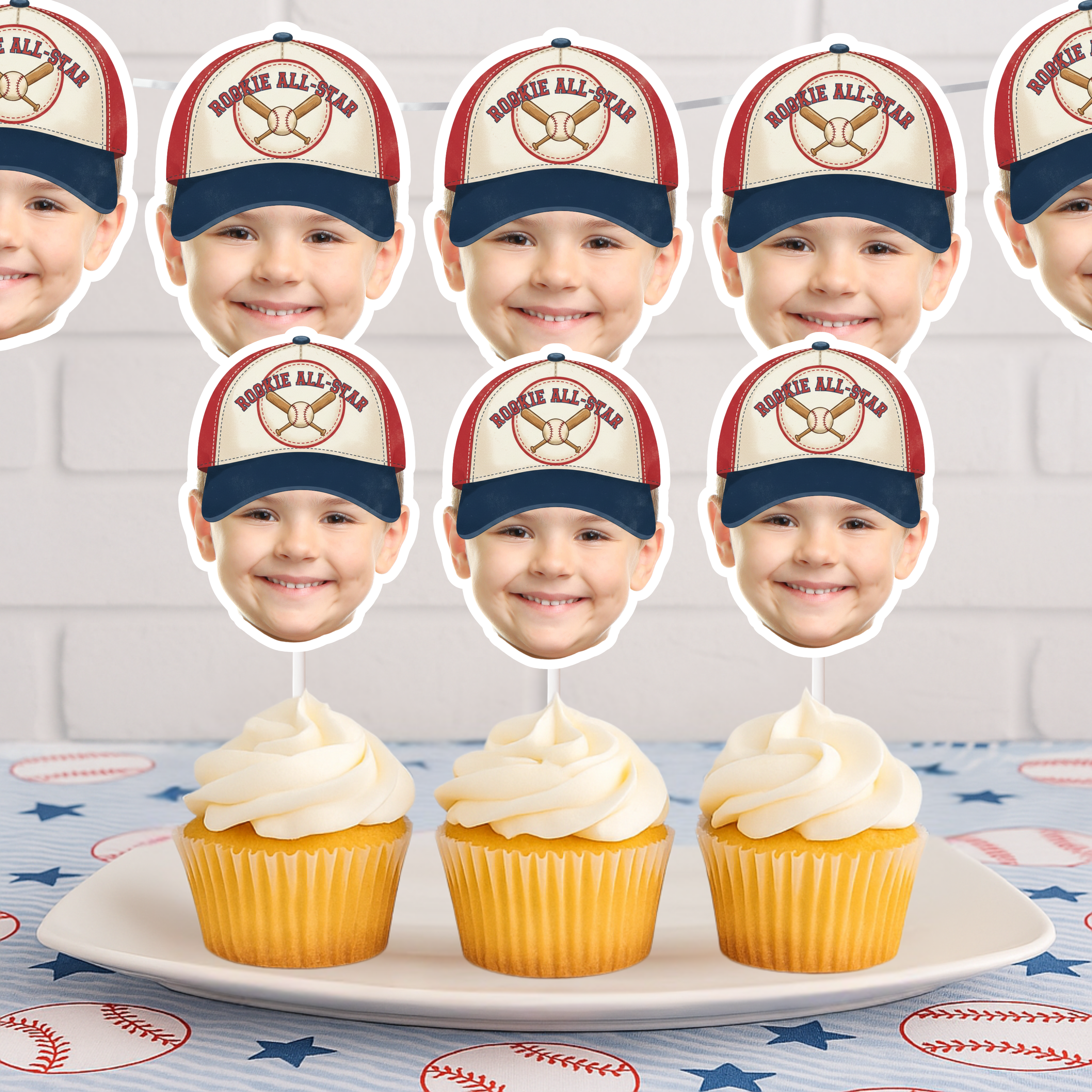 Photo Baseball Rookie All American Cupcake Toppers featuring vintage Rookie All-Star cap design in red white and blue displayed on frosted cupcakes for baseball first birthday party dessert table decor. Included in the set is a matching banner. 