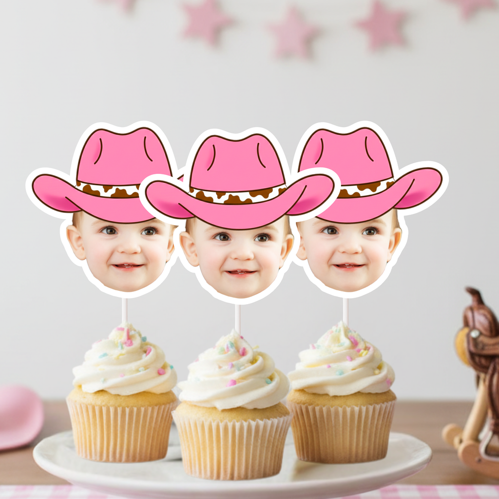 Custom pink cowgirl hat face cupcake toppers styled on frosted cupcakes with soft western birthday decor. Personalized rodeo cupcake decorations designed for first birthdays, Two Wild toddler parties, pony celebrations, and pink country themed events. A playful cowgirl party accessory that adds a custom western touch to smash cakes and dessert table styling.
