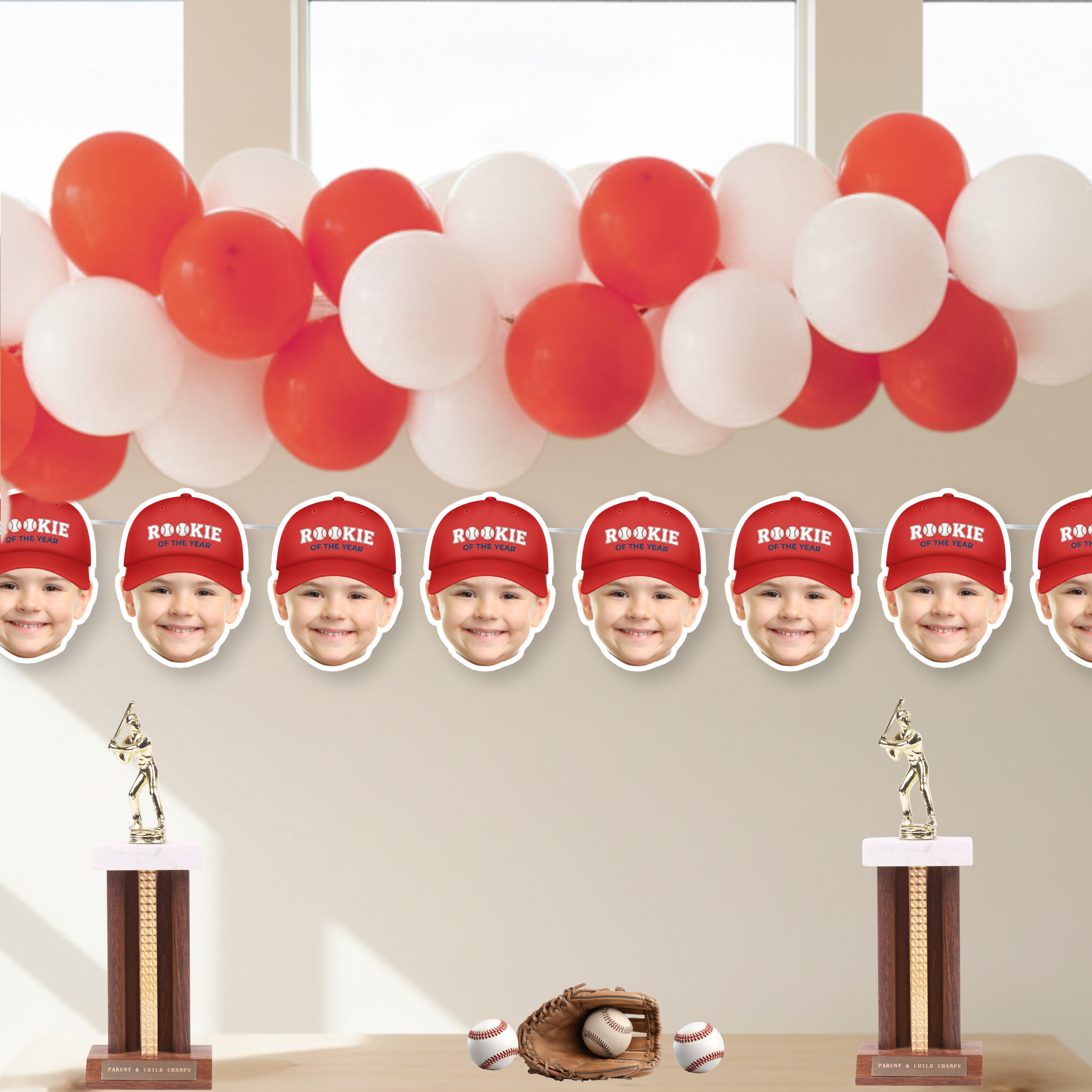 Rookie of the Year photo baseball banner featuring red cap style under red and white balloon garland, personalized face cutouts for baseball birthday party decorations and dessert table backdrop.